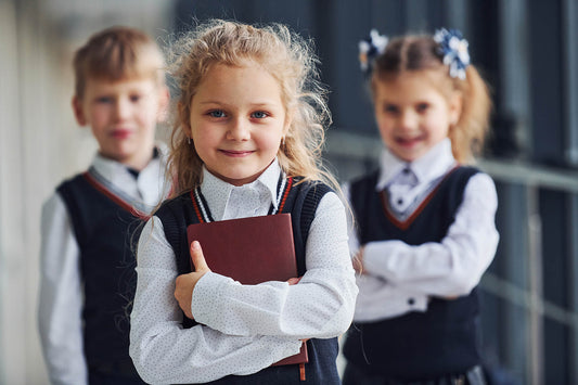 Crianças com uniforme escolar caminhando juntas no corredor da escola com mochilas e livros - DuePay 2026 São Paulo
